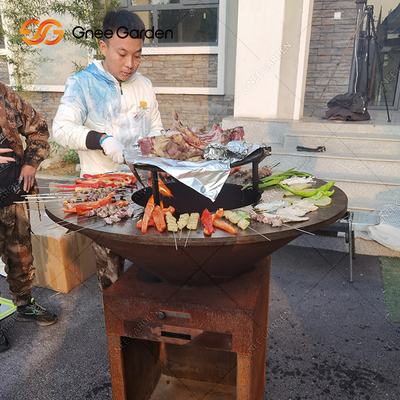 Gli amici della famiglia ARROSTISCONO COL BARBECUE la griglia d'acciaio del barbecue di Brasero della griglia di Corten della ruggine all'aperto d'acciaio